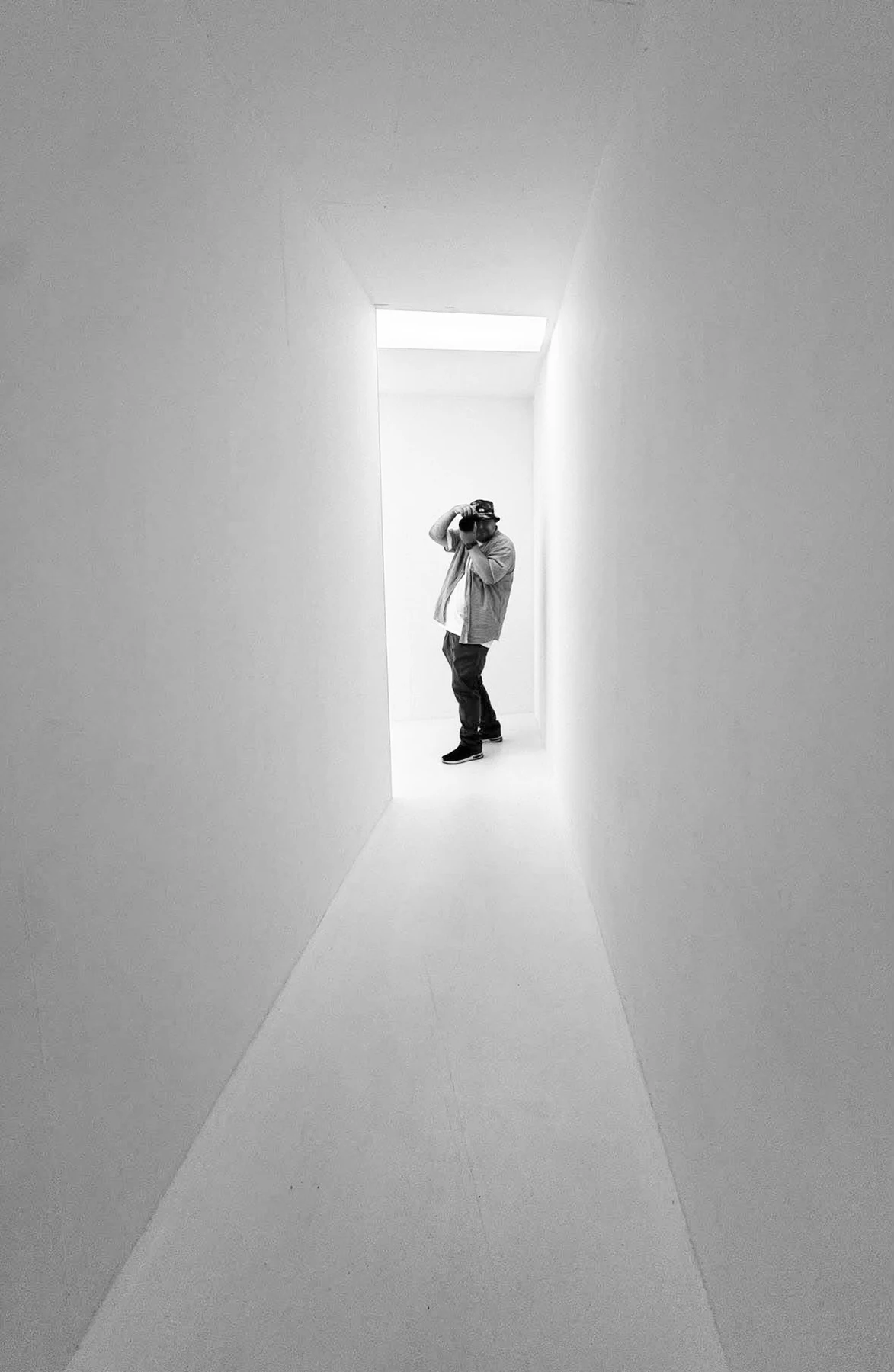 Ole Martin fotograferer i et lyst arkitektonisk rum